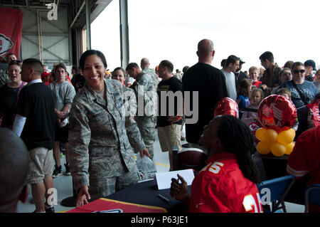 Kansas City Chiefs players autograph merchandise for Tech. Sgt. Jessica Harrell, line recruiter assigned to the 442d Fighter Wing at Whiteman Air Force Base, Mo., April 30, 2016. Service members and their families enjoyed autographs, free food and many other activities during the Military Appreciation Day event which aired the NFL draft 4th, 5th and 6th round picks live at Whiteman. (U.S. Air Force photo by Airman 1st Class Missy Sterling/Released) Stock Photo