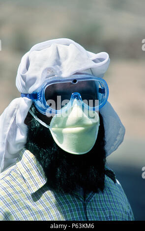 Asphalt worker with mask and protector goggles in the 48 degree heat, Makkah Province, Saudi Arabia Stock Photo