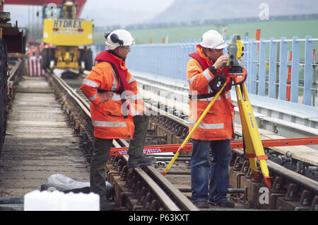 Checking work replacing old bridge sections on a railway crossing on the northern coast of Morecombe Bay for an upgrading programme, England, UK Stock Photo