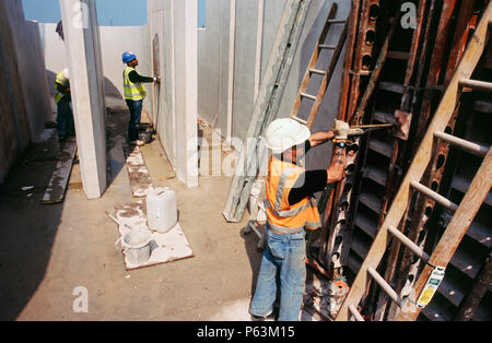 Finishing work on concrete flow channels at the wastewater treatment works for Wigan, England, UK Stock Photo