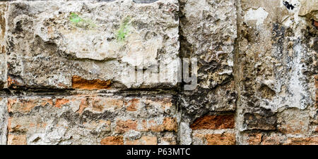 Grunge old bricklaying wall fragment from red bricks and damaged plaster background. Stock Photo