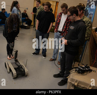 During Knoxville Navy Week, Gibbs High School students operated a Boeing 310 Small Unmanned Ground Vehicle from Explosive Ordnance Disposal Mobile Unit 6 in Corryton, Tennessee. Navy personnel demonstrated the robot's use in bomb detection, disposal, and safety operations. The event highlighted career opportunities in EOD, robotics, STEM fields, and military service, emphasizing hands-on experience, teamwork, technical skills, and awareness of operational procedures and Navy missions. Stock Photo