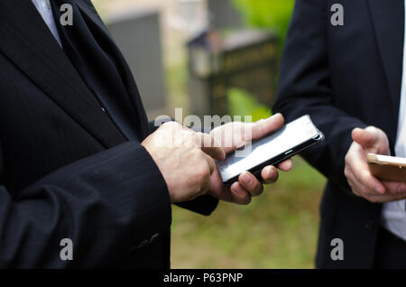 Elderly man in dark suit using a mobile phone Stock Photo