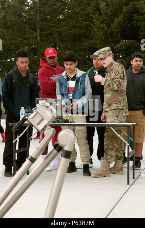 At Joint Base Lewis-McChord, Washington, on April 13, 2016, students from Tacoma Independent School District practiced operating a TALON robotic system during a hands-on education event. The demonstration introduced participants to military career paths including canine handling, combat medic, and explosives ordnance disposal. Students engaged in STEM-focused activities, learning robotics operation, teamwork, mission planning, and safety protocols while gaining insight into Army operations and technology use in field scenarios. Stock Photo