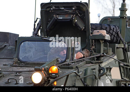 A soldier assigned to Headquarters and Headquarters Troop, 3rd Squadron, 2nd Cavalry Regiment wipes down the glass in the driver’s seat of a Stryker Armored Fighting Vehicle as his unit prepares and stages vehicles before movement during a field exercise, April 25, at Adazi Military Base, Latvia. Soldiers from five North Atlantic Treaty Organization nations, including Latvia, Canada, Germany, Lithuania and the U.S. have been conducting a variety of training together during Summer Shield XIII, an annual two-week long interoperability training event in Latvia.(U.S. Army photo by Sgt. Paige Behri Stock Photo