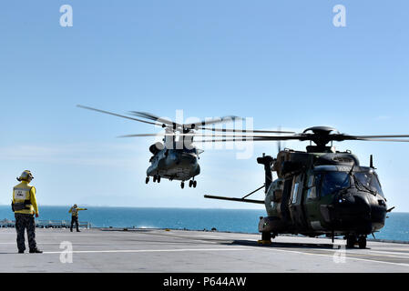 Australian Royal Navy Leading Seamans Timu and Harrison work on the flight deck with MRH90 and CH-53 helicopters during Exercise Sea Explorer aboard the HMAS Canberra at Sea June 9, 2018. The helicopters and soldiers were practicing rescue and recovery missions as part of the overall Ex Sea Series 18. The series is designed to train Australian Forces and get them amphibious ready. U.S. Marines and Sailors with Marine Rotational Force - Darwin 18 are working alongside the Australian Defence Force as part of the Amphibious Task Group. (U.S. Marine Corps photo by Staff Sgt. Daniel Wetzel) Stock Photo