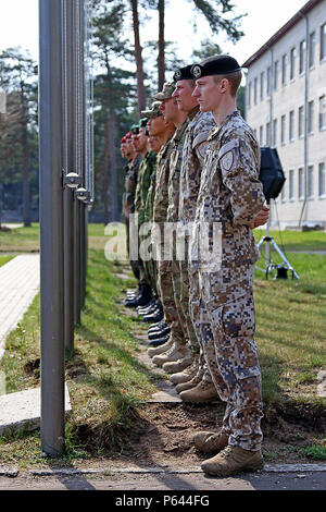 Soldiers from five of the North Atlantic Treaty Organization nations participating in Summer Shield XIII stand ready to lower their country’s flag during the closing ceremony of Summer Shield XIII, April 29, at Adazi Military Base, Latvia. Soldiers from Latvia, Canada, Germany, Lithuania and the U.S. have been conducting a variety of training together during Summer Shield XIII, an annual two-week long interoperability training event in Latvia. Soldiers from Finland and Poland were also present as observers.(U.S. Army photo by Sgt. Paige Behringer, 10th Press Camp Headquarters) Stock Photo