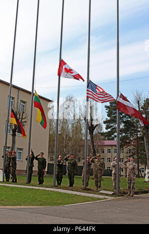 Soldiers from five North Atlantic Treaty Organization nations participating in Summer Shield XIII lower their country’s flag during the exercise’s closing ceremony of, April 29, at Adazi Military Base, Latvia. Soldiers from Latvia, Canada, Germany, Lithuania and the U.S. have been conducting a variety of training together during Summer Shield XIII, an annual two-week long interoperability training event in Latvia. Soldiers from Finland and Poland were also present as observers.(U.S. Army photo by Sgt. Paige Behringer, 10th Press Camp Headquarters) Stock Photo