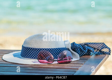 sunprotection objects on the beach in holiday sunglasses and white hat. Leisure in summer with copy space. Minimal style.Summer flat lay scenery.beach accessories on turquoise tropical background Stock Photo