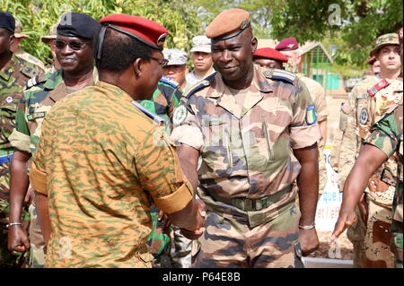 General Pingrenoma Zagre (left), Chief of Defense Staff for Burkina Faso Armed Forces, greets an Ivory Coast servicemember during the Western Accord 16 Opening Day Ceremony May 2, 2016 at Camp Zagre, Ouagadougou, Burkina Faso. Western Accord 16 is an annual combined, joint exercise designed to increase the ability of African partner forces and the U.S. to exercise participants’ capability and capacity to conduct African Union/United Nation mandated Peace Operations. (U.S. Army photo by Staff Sgt. Candace Mundt/Released) Stock Photo