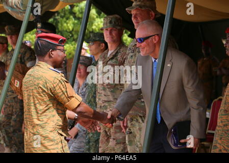 General Pingrenoma Zagre (left), Chief of Defense Staff for Burkina Faso Armed Forces, shakes hands with David K. Young (right), the First Counsellor, Senior Advisor, and Deputy Chief of Mission for the U.S. Embassy of Ouagadougou, Burkina Faso, following his speech during the Western Accord 16 Opening Day Ceremony May 2, 2016 at Camp Zagre, Ouagadougou, Burkina Faso. Western Accord 16 is an annual combined, joint exercise designed to increase the ability of African partner forces and the U.S. to exercise participants’ capability and capacity to conduct African Union/United Nation mandated Pea Stock Photo