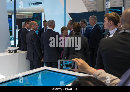 BERLIN, GERMANY - APRIL 25, 2018: Visit of Chancellor of Germany Angela Merkel to the stand of Liebherr Group. Exhibition ILA Berlin Air Show 2018. Stock Photo