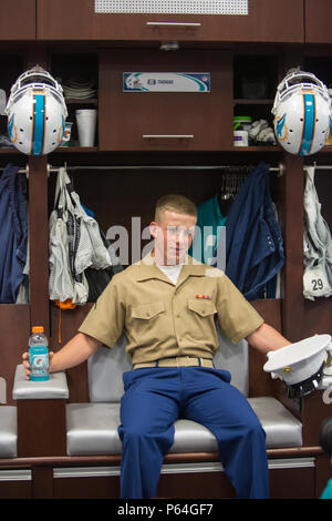 Pfc. Geoffery Smith, an ammunition technician with Combat Logistics Regiment 25, poses for a photo in the players locker room during a tour of the Miami Dolphins training facility in Fort Lauderdale, Fla., May 4, 2016. The event took place as a part of Fleet Week Port Everglades which lasts from May 2-8, and will give the community of South Florida the opportunity to interact with the Marines and Sailors from several fleet ships as well as see up-close and personal some of the capabilities and equipment the Marine Corps employs. (U.S. Marine Corps photo by Cpl. Michelle Reif/Released.) Stock Photo