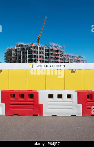 Hoarding and protective barrier surrounding University Campus Suffolk halls of residence building under construction, Ipswich, Suffolk, UK Stock Photo
