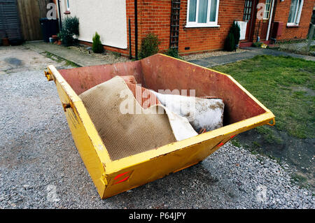 Skip in front of a house under refurbishment Stock Photo