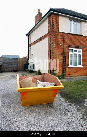 Skip in front of a house under refurbishment Stock Photo