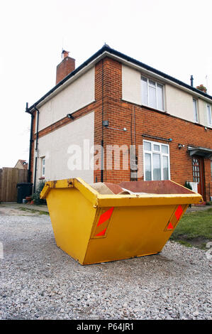 Skip in front of a house under refurbishment Stock Photo