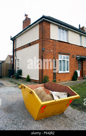 Skip in front of a house under refurbishment Stock Photo