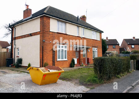 Skip in front of a house under refurbishment Stock Photo