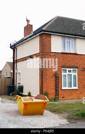 Skip in front of a house under refurbishment Stock Photo