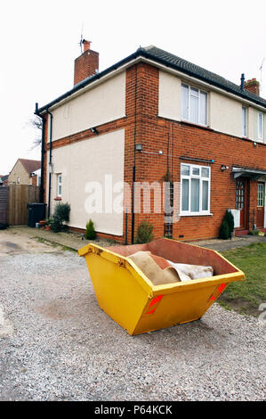 Skip in front of a house under refurbishment Stock Photo