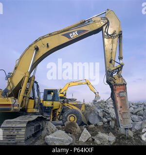 Hydraulic breaker attachment on Caterpillar excavator with Komatsu wheeled loader and excavator in background. John F Kennedy International Airport. N Stock Photo