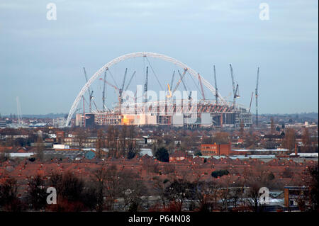 New Wembley Stadium under construction in January 2005, looking at the arch and cranes across rooftops from the south at dusk, London, UK Stock Photo