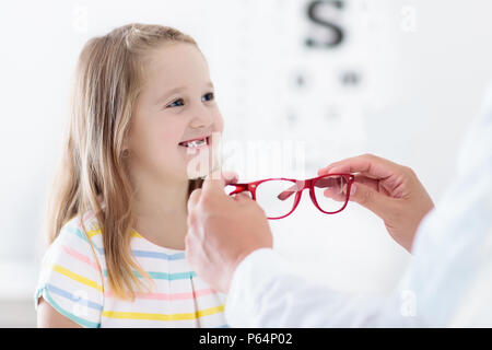 Child at eye sight test. Little kid selecting glasses at optician store. Eyesight measurement for school kids. Eye wear for children. Doctor performin Stock Photo