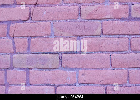 Brick wall background featuring old and distressed red and pink color clay bricks in traditional running bond pattern Stock Photo