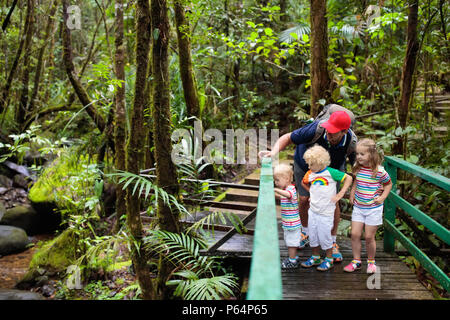 Family hiking in jungle. Father and kids on a hike in tropical rainforest. Dad and children walk in exotic forest. Travel with child. Borneo jungle an Stock Photo