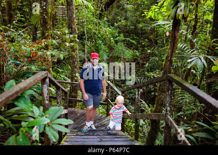 Family hiking in jungle. Father and kids on a hike in tropical rainforest. Dad and children walk in exotic forest. Travel with child. Borneo jungle an Stock Photo