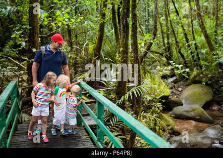 Family hiking in jungle. Father and kids on a hike in tropical rainforest. Dad and children walk in exotic forest. Travel with child. Borneo jungle an Stock Photo