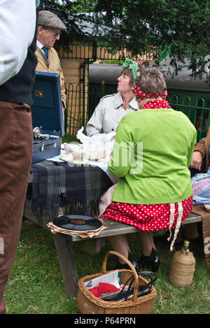 A group of enactors in period civilian dress having a picnic at the ‘War on the Line’ event 2018 at Ropley Station on the Watercress Line railway Stock Photo