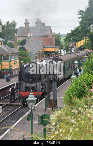 Steam locomotive 92212 pulling a passenger train at Ropley Station during the War on the Line event 2018 on the Mid Hants Railway Watercress Line Stock Photo