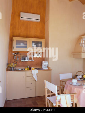 Partial view of a dining table beside a kitchenette Stock Photo