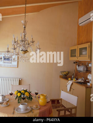 Partial view of a dining table near a kitchenette Stock Photo