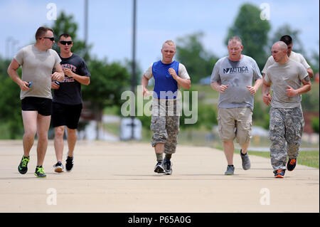 Army Pfc Harlan Troutman,  with the Tennessee Army National Guard’s H Troop, 2nd Squadron, 278th Armored Cavalry Regiment, gets encouragement from other Soldiers and fellow tank crew members as he stretches out his stride during the end of a one-mile run after competing other physically demanding tasks during the Gen. Gordon Sullivan Cup best tank crew competition at Fort Benning, Ga., Sunday, May 1, 2016. Competitors were required to move the wheel over a specific route in the shorter time possible. The Sullivan Cup tests tanks crews from throughout the Army on everything from gunnery to moun Stock Photo