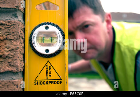 Builder using a spirit level. Stock Photo