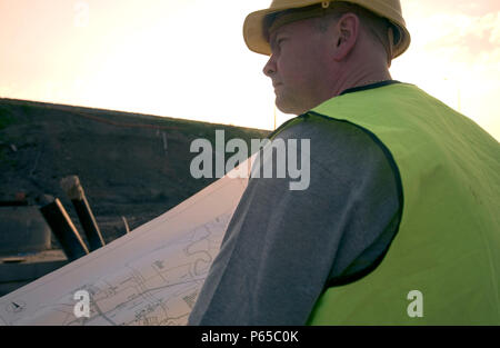Building technician checking plan on site Stock Photo