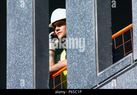 Construction worker using a mobile phone on site. Stock Photo