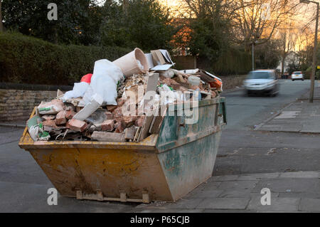 Overloaded skip on a London street Stock Photo