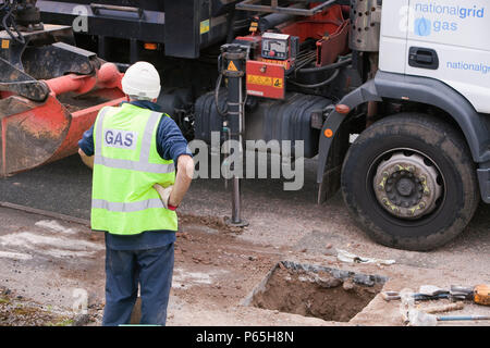 British Gas workers replacing old metal gas pipes with plastic ones as part of an upgrade to comply with modern health and safety legislation, in Ambl Stock Photo