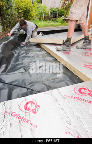 Builders lay under floor insulation into a house extension in Ambleside, UK. Stock Photo