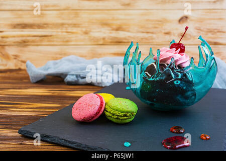 Sweet dessert and macaron in caramel bowl on wooden background Stock Photo