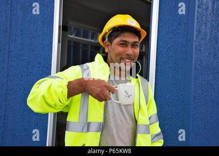 Construction worker having a cup of tea on a building site, England, UK. Stock Photo