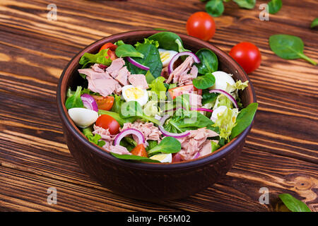 Salad with tuna, tomatoes, quail eggs, asparagus and onions on wooden background Stock Photo