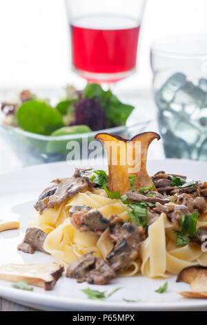 Pasta mit Pilz-Sauce auf einem Teller Stock Photo