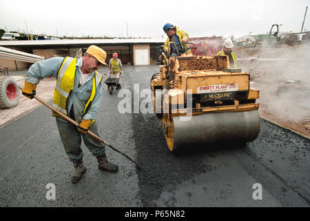 Rolling coated chipings into hot rolled asphalt wearing course with vibratrory roller. Stock Photo