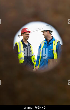 Two construction workers smiling on a building site Stock Photo