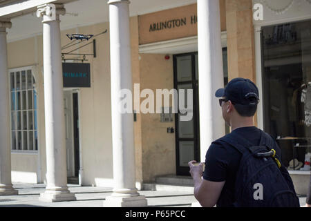 man flying small toy drone in downtown Bath England UK Stock Photo